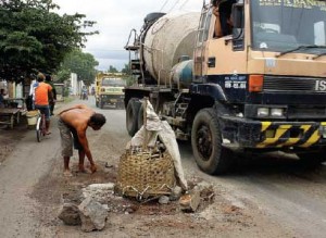 GANGGU PENGGUNA JALAN: Kendaraan besar menghindari jalan rusak di Dusun Sampangan, Kedungrejo, Muncar, yesterday.