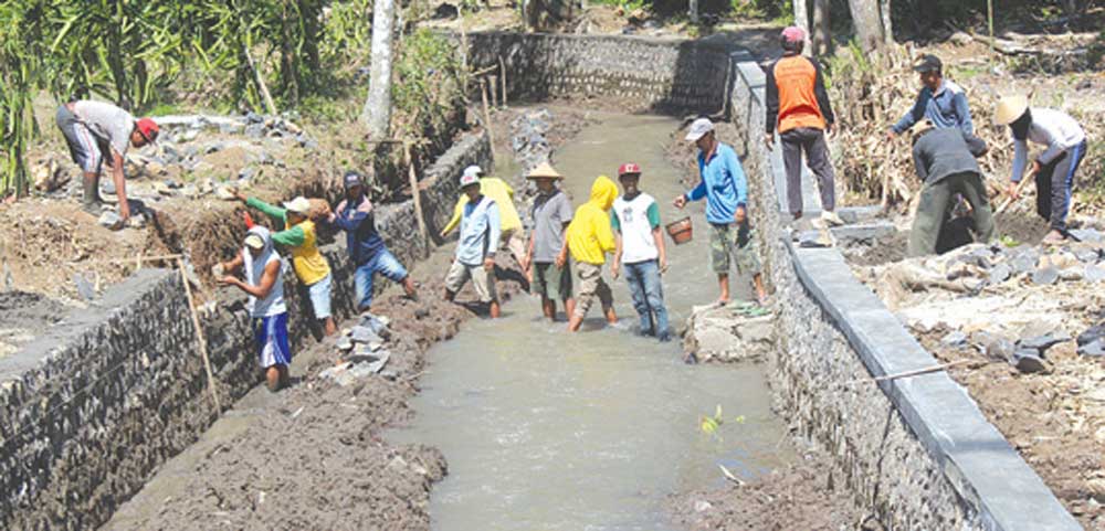 Pekerja-memasang-plengsengan-di-Sungai-Apur-di-Dusun-Ringinmulyo,-Desa-Ringintelu,-Kecamatan-Bangorejo,-Banyuwangi,-kemarin