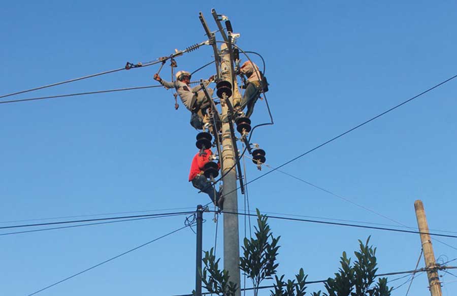 Petugas-memasang-kabel-di-tiang-baru-yang-berukuran-lebih-besar-di-Desa-Kecamatan-Gambiran,-Banyuwangi,-kemarin