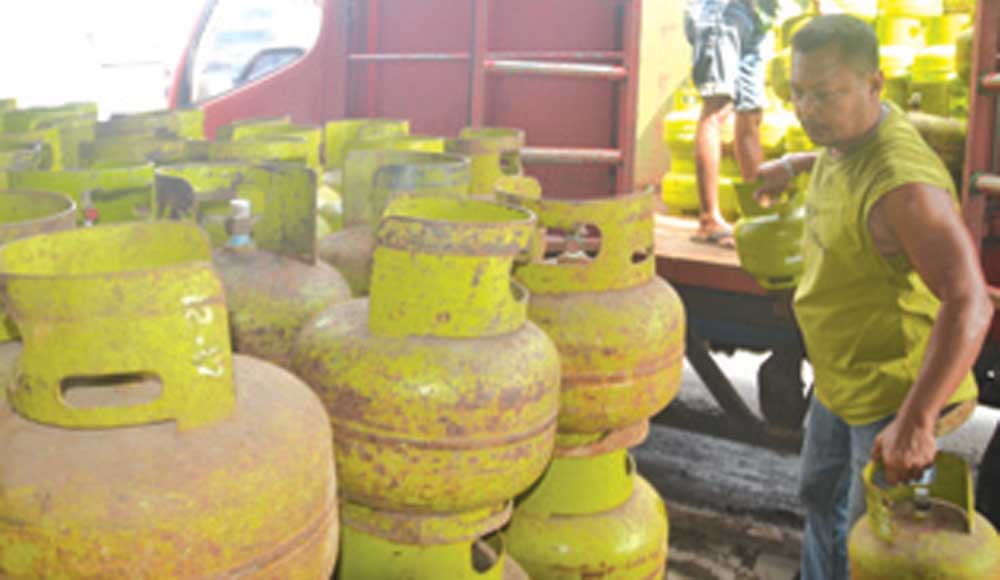 Hendrik-memindah-tabung-gas-elpiji-dari-mobil-ke-pangkalan-di-Kecamatan-Rogojampi,-Banyuwangi,-kemarin