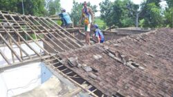 Warga-membersihkan-rumah-milik-Asih-yang-ambruk-di-Dusun-Bolot,-Desa-Aliyan,-Kecamatan-Rogojampi,-Banyuwangi,-kemarin
