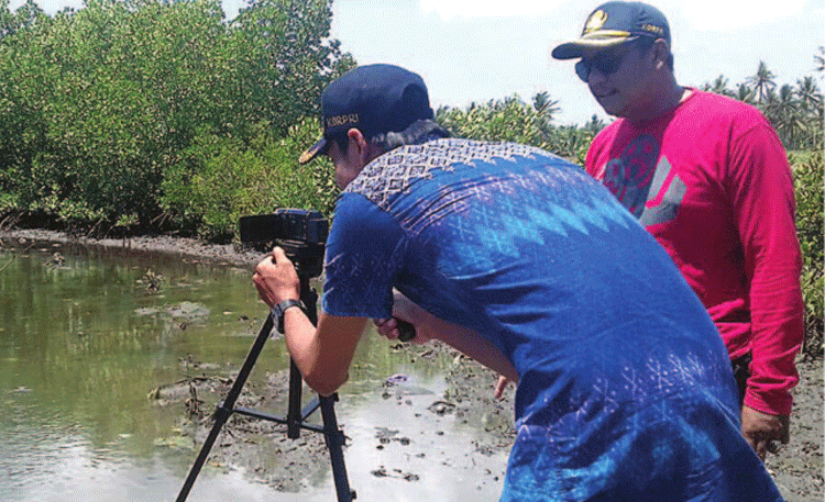 kepala-desa-kedungasri-sunaryo-kanan-memberikan-petunjuk-objek-tanaman-mangrove-untuk-diambil-gambar-pada-tim-video-kreatif-kemarin