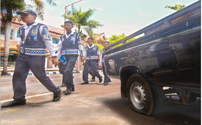 Petugas-patroli-jalan-dari-Dinas-Perhubungan-melakukan-tindakan-gembos-ban,-di-depan-SMPN-1-Banyuwangi.