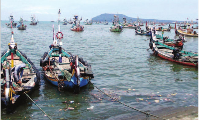 Seorang-nelayan-mengecek-kapal-yang-disandarkan-di-Pelabuhan-Muncar-kemarin