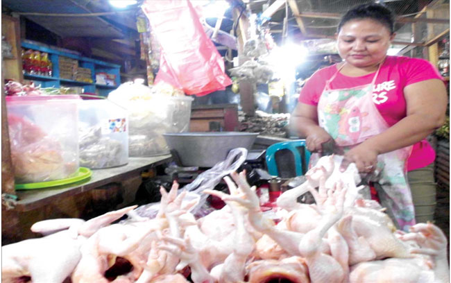 Susi-pedagang-ayam-di-Pasar-Banyuwangi-itu-sedang-menunggu-pelanggan-sambil-memotong-ayam-kemarin