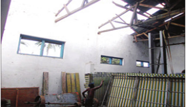 Hadis-menunjukkan-atap-di-KUD-Songgon-yang-rusak-diterjang-angin