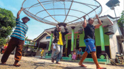 Pekerja-mengangkat-antena-parabola-dari-rumah-milk-Muhlas-di-Dusun-Pecemengan,-Desa-Kecamatan-Blimbingsari.