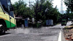 Bus-melewati-jalan-rusak-dan-bergelombang-di-Jalan-Raya-Situbondo,-Kecamatan-Wongsorejo,-Banyuwangi.