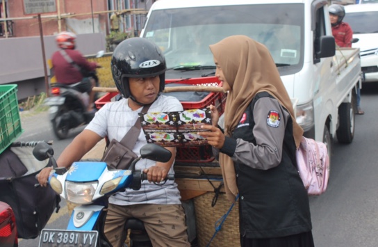 Photo : An officer from the Banyuwangi KPU socializes election matters to road users. (Doc. Ron).