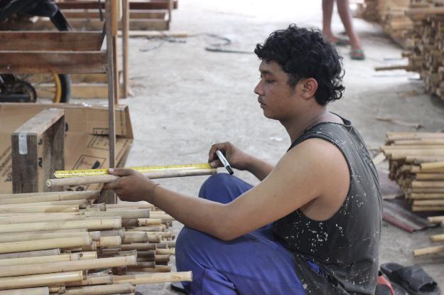 Pekerja sedang memilih dan mengukur bambu yang akan segera di proses menjadi seruling. (Foto: Rony. Jurnalnews). 