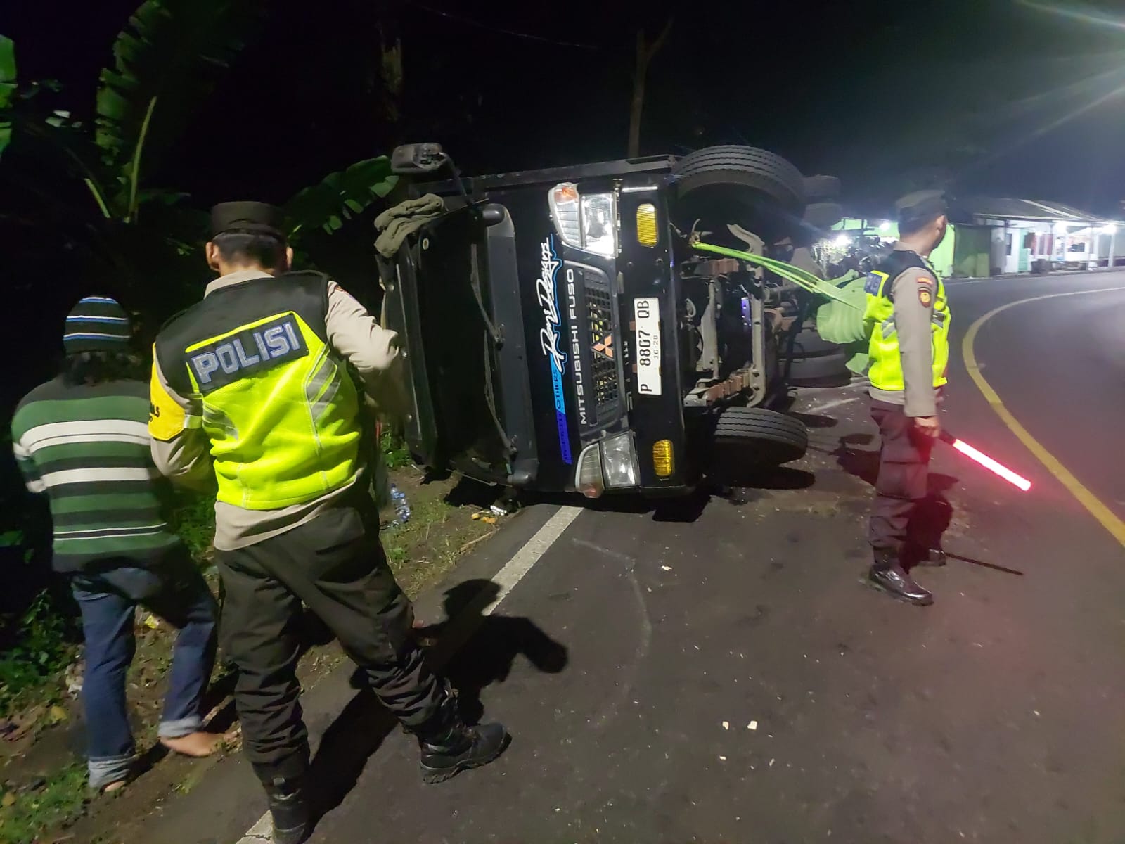 muatan-limbah-triplek-terlalu-berat,-truk-angkut-terguling-di-kecamatan-silo-jember