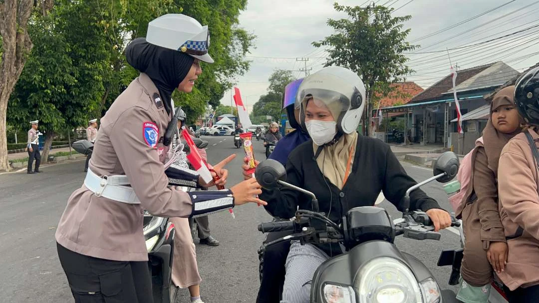 sambut-hari-jadi,-polwan-di-banyuwangi-bagi-bagi-cokelat-dan-bendera-ke-pengguna-jalan