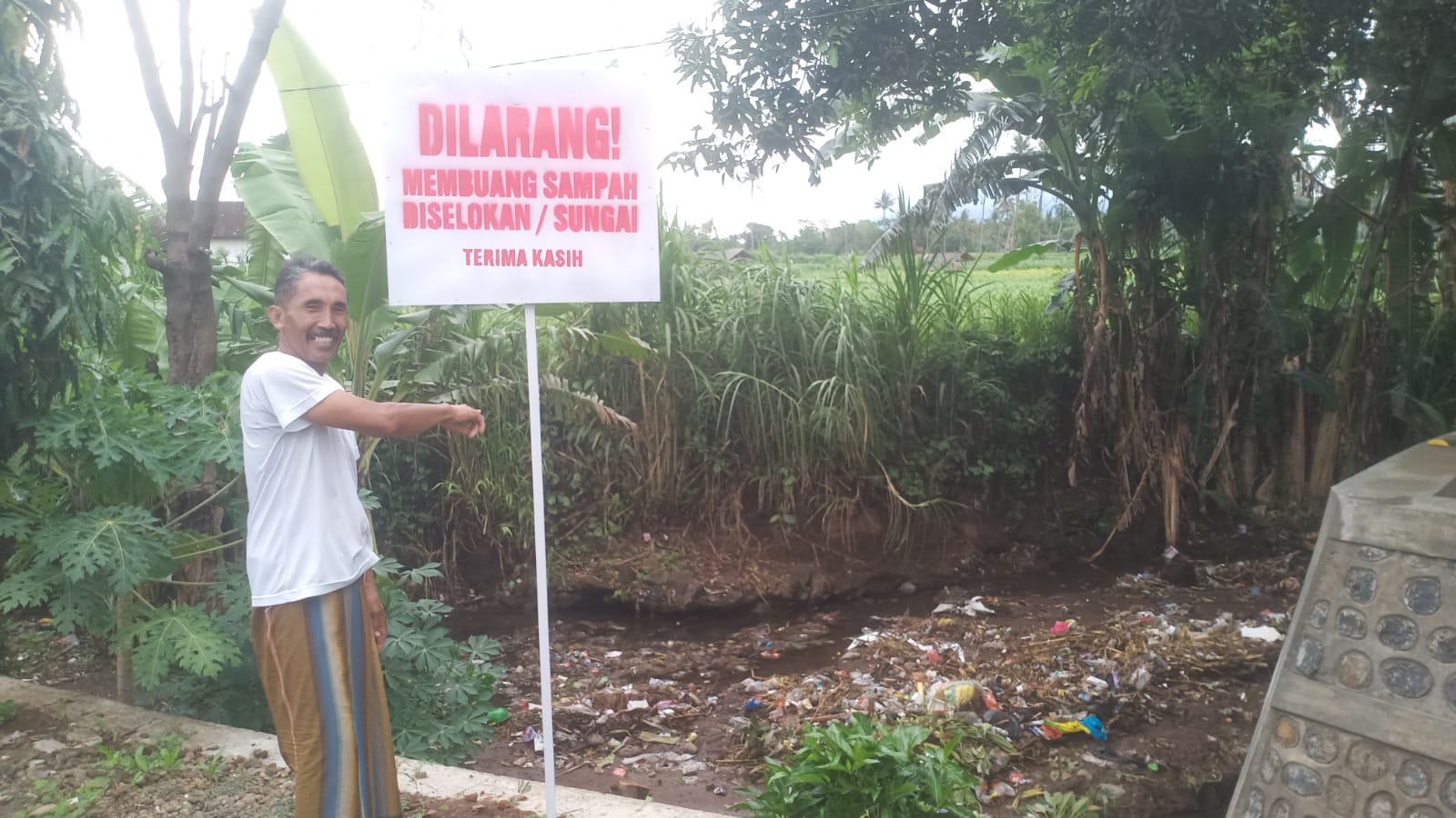 ketua-rt-pasang-plakat-larangan-buang-sampah-di-sungai-krajan-wongsorejo,-warga-diminta-lebih-peduli-lingkungan