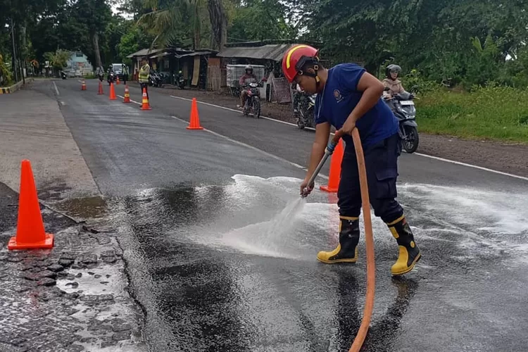 jalan-raya-benelan-kidul-licin-gegara-solar-tumpah!-pengendara-sampai-jatuh,-damkarmat-banyuwangi-turun-tangan