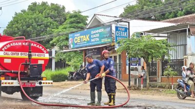 jalan-berlumpur-di-jembatan-mayit-dikeluhkan-warga,-damkarmat-genteng-kerahkan-ribuan-liter-air